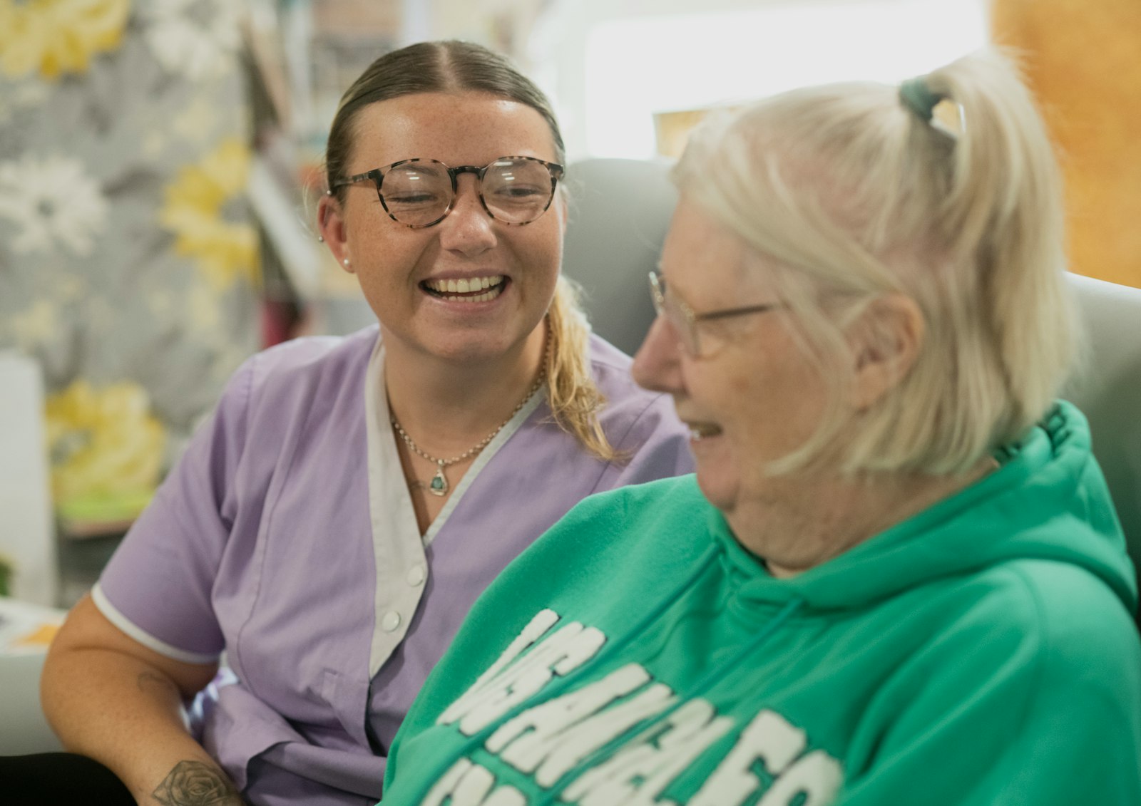 Zwei Frauen lachen gemeinsam — Gesellschaft und Nähe im Alltag.